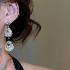 Close-up of elegant double water drop silver earrings with sparkling white crystals