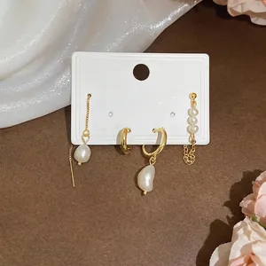 Elegant four-piece set of gold earrings with freshwater pearls and French style tassels