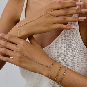 Minimalist stainless steel hand chains in gold and silver finish on female model