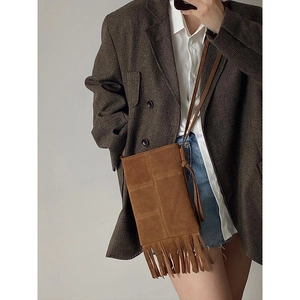 Brown suede bohemian crossbody bag with fringe tassels shown in an OOTD street style look