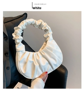 Detailed view of white pleated cloud bag with soft matte faux leather texture
