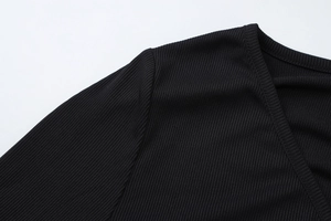 Detaillierte Makroansicht der gerippten Stricktextur des schwarzen Langarm-Cardigans