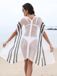 Detailed close-up of white crochet beach cover-up with black stripes and hollow-out mesh