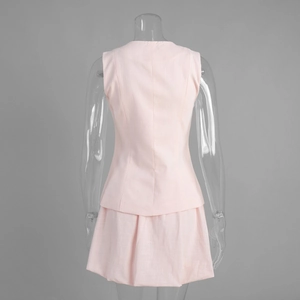 Détail d'un ensemble deux pièces rose clair avec haut sans manches et mini-jupe plissée