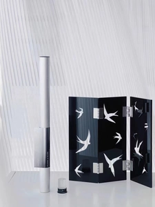 Detail of minimalist black folding screen with swallow motifs and silver incense tube