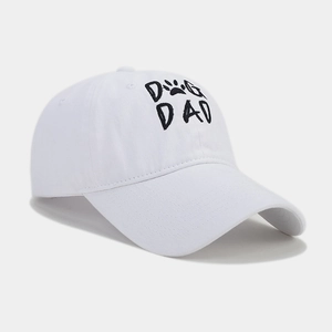 Close-up of black Dog Dad embroidery and paw print on white cotton baseball cap
