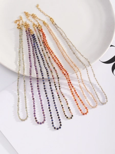 Detail of colorful faceted natural stone beaded necklaces with gold spacer beads