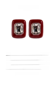Detailed view of dark red square enamel earrings with gold-plated brass and zircon accents
