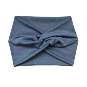 Detail of dark blue-grey wide yoga headband showing knitted texture and center twist