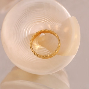 Detail of 18K gold-plated stainless steel ring with heart scale pattern in a shell