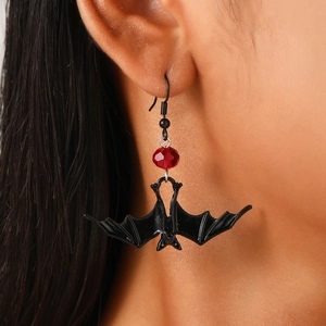 Gothic Halloween bat earrings with red beads shown on model in a detailed side view