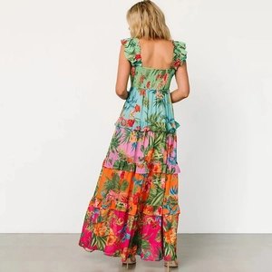 Back view of a tiered floral beach maxi dress with ruffled straps and tropical prints