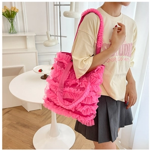 Détail d'un sac cabas en tulle rose avec des volants et une texture légère