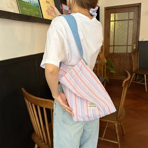 Détail de la texture du sac en toile rayé plissé montrant la qualité supérieure du tissu