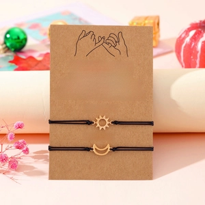 Detail of sun and moon couple bracelets on a message card with festive decor