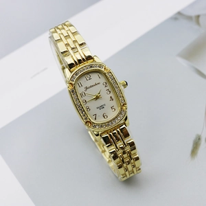 Elegant women gold quartz watch with rhinestones and oval dial on light background