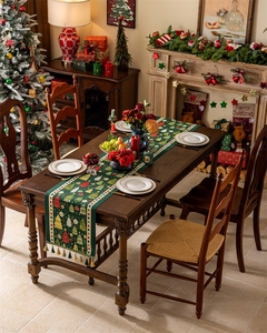 Detail of green Christmas table runner with festive tree patterns and tassel decorations