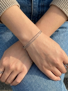 Detail view of silver double-layered snake chain and beaded bracelet with adjustable clasp