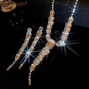 Detailed view of luxury square crystal fringe necklace and earring set on black backdrop
