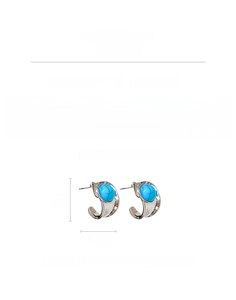 Detail of C-shaped earrings with sky blue turquoise stones and silver needle pins