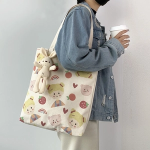 Detail der Canvas-Tasche mit süßen Comic-Prints und kleinem Hasen-Plüsch-Accessoire
