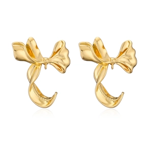 Macro shot of 18K gold plated bow earrings showing metallic texture on white background