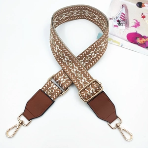 Close-up of bohemian 3.8cm wide jacquard bag strap with brown leather and gold metal clips