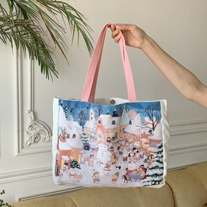 Détail du sac cabas en toile avec illustration de ville d'hiver et poignées roses et pression