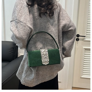 Detail of green suede evening bag with sparkling rhinestone strip and silver chain strap