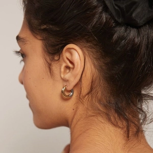 Close-up of 4mm two-tone gold and silver plated stainless steel hoop earrings on model