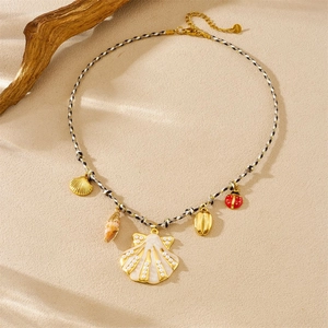 Detailed view of sea shell charms and ladybug pendant on a woven ocean theme necklace