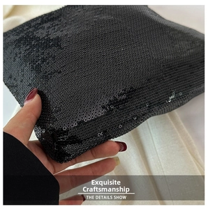 Vue détaillée des paillettes noires scintillantes sur le sac porté à la main