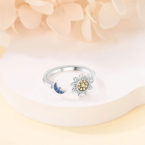 Detail of adjustable silver ring featuring a yellow sun and blue crescent moon stones