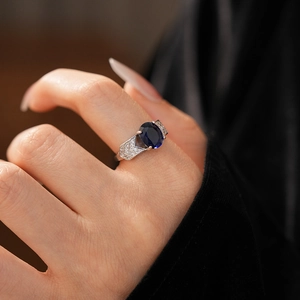 Détail d'une bague en argent avec pierre précieuse bleue ovale et zircons scintillants