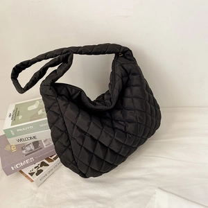 Quilted black nylon puffer tote bag with woven shoulder strap and large capacity