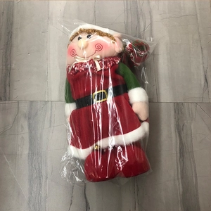 Détail d'un lutin de Noël en peluche avec tissu rouge et vert et boucle de ceinture dorée