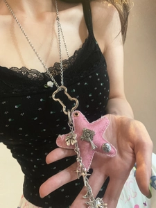 Detailed view of pink fabric star pendant with gothic metallic charms on silver chain