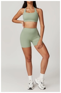 Dettaglio del set yoga verde salvia con pantaloncini a vita alta e reggiseno sportivo