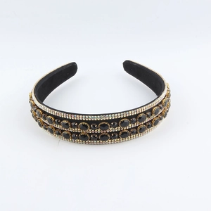 Close-up of double-layered black headband with rhinestones and oval gemstones