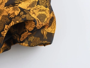 Primo piano di tessuto jacquard nero di qualità con eleganti motivi floreali dorati
