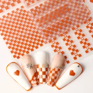 Detail of orange checkerboard and heart nail stickers with French tip design examples
