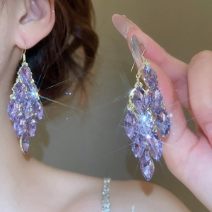 Detail of long tassel earrings with purple marquise-cut crystals and golden hooks