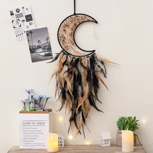 Detailed view of moon-shaped dream catcher with black feathers and Tree of Life wire wrap