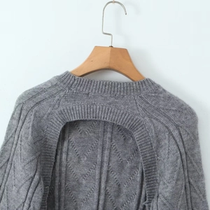 Detail view of grey cable-knit sweater featuring backless cutout and bow tie design
