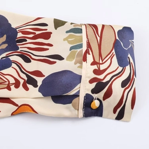 Détail d'un revers de manche boutonné sur une chemise en satin à imprimé floral vintage