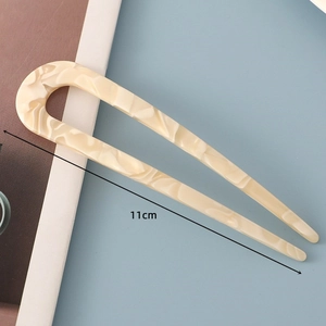 Detail of 11cm acetate U-shaped hair pin with cream marble texture on blue surface