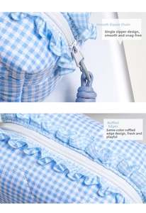 Detail of smooth white zipper and ruffle lace edge on blue checkered vanity bag