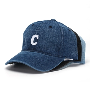 Detail of embroidered letter C on navy denim baseball cap with 100% cotton wash label