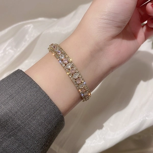 Close-up of pink and white cubic zirconia stones on a three-row gold plated bangle