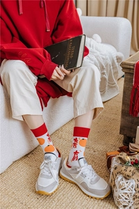 Detail of red festive crew socks with Lucky Mandarin citrus pattern and Chinese characters